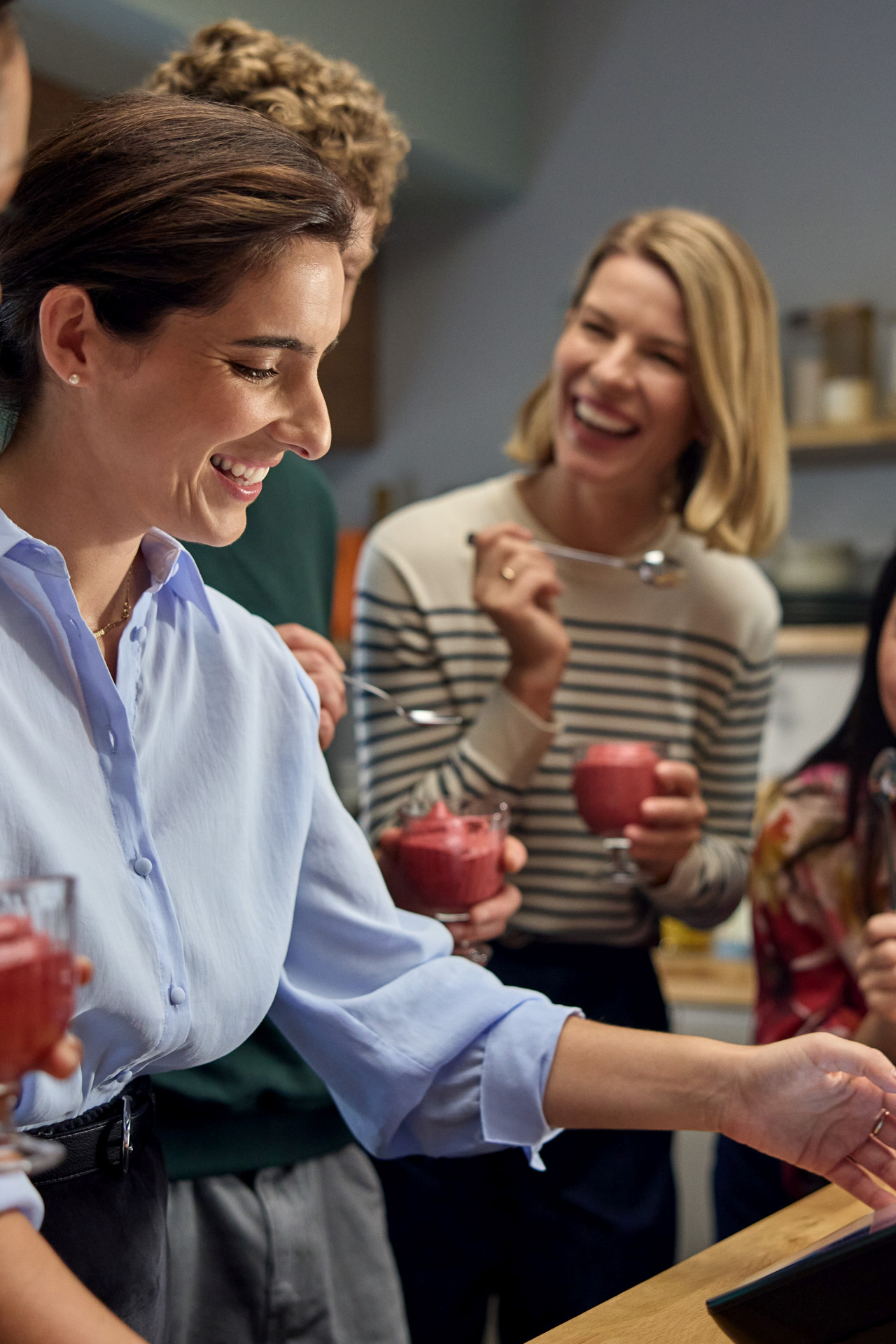 Group preparing and enjoying dessert around a Thermomix® TM7 in a modern kitchen.