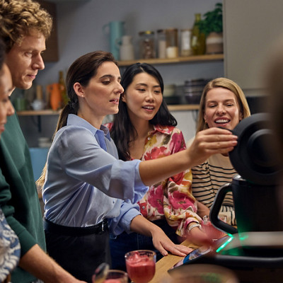 Group of people standing together in kitchen and trying bread