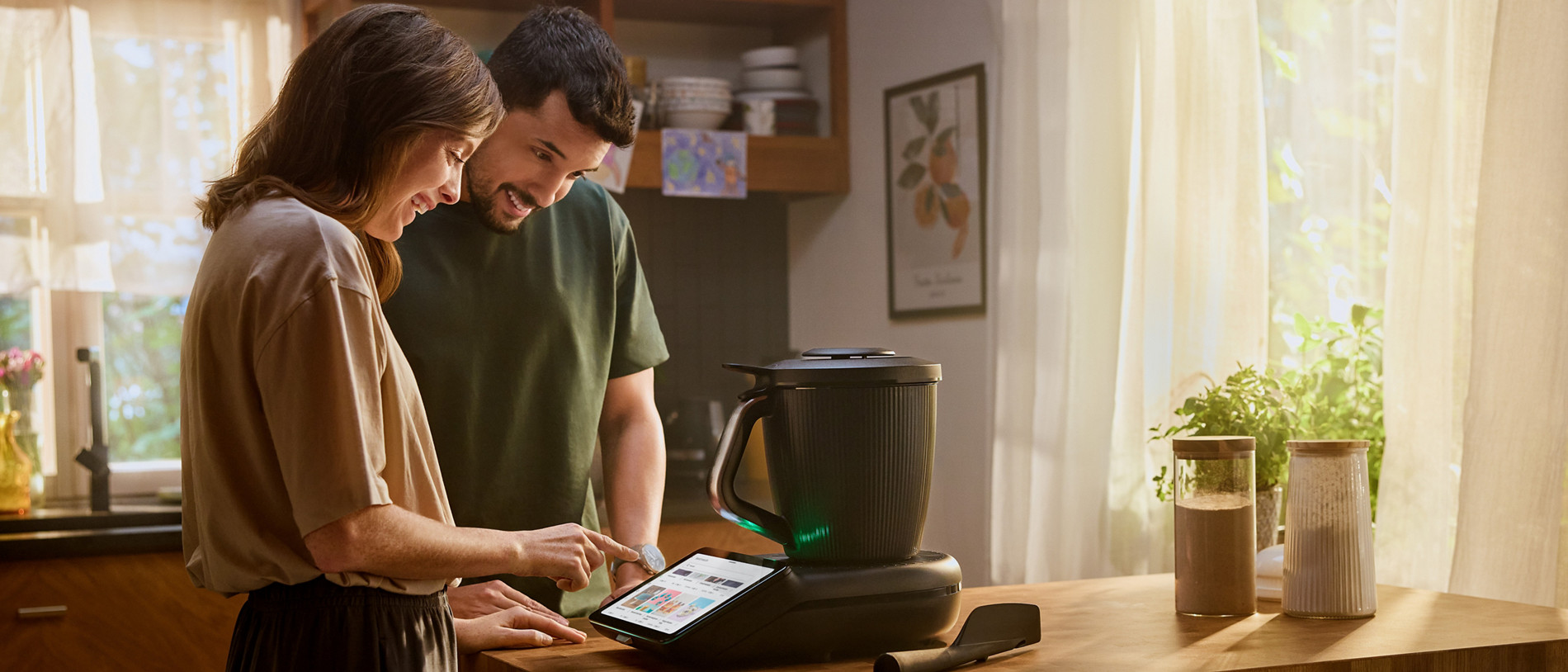 Ein junges Paar kocht voller Freude in seiner Küche mit dem Thermomix® TM7.