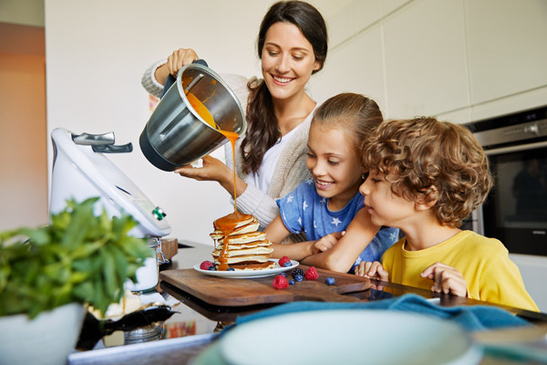 Mulher a cozinhar na Bimby® TM6 com os filhos