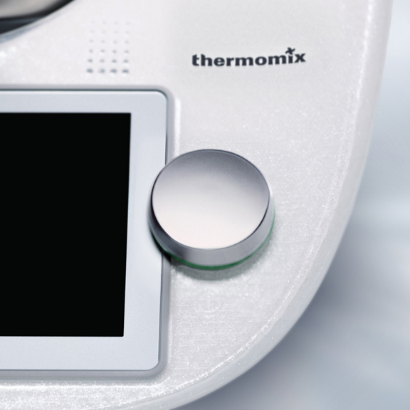 Nahaufnahme des Thermomix TM6 Bedienknopfs und Touchscreens mit sichtbarem Markenlogo