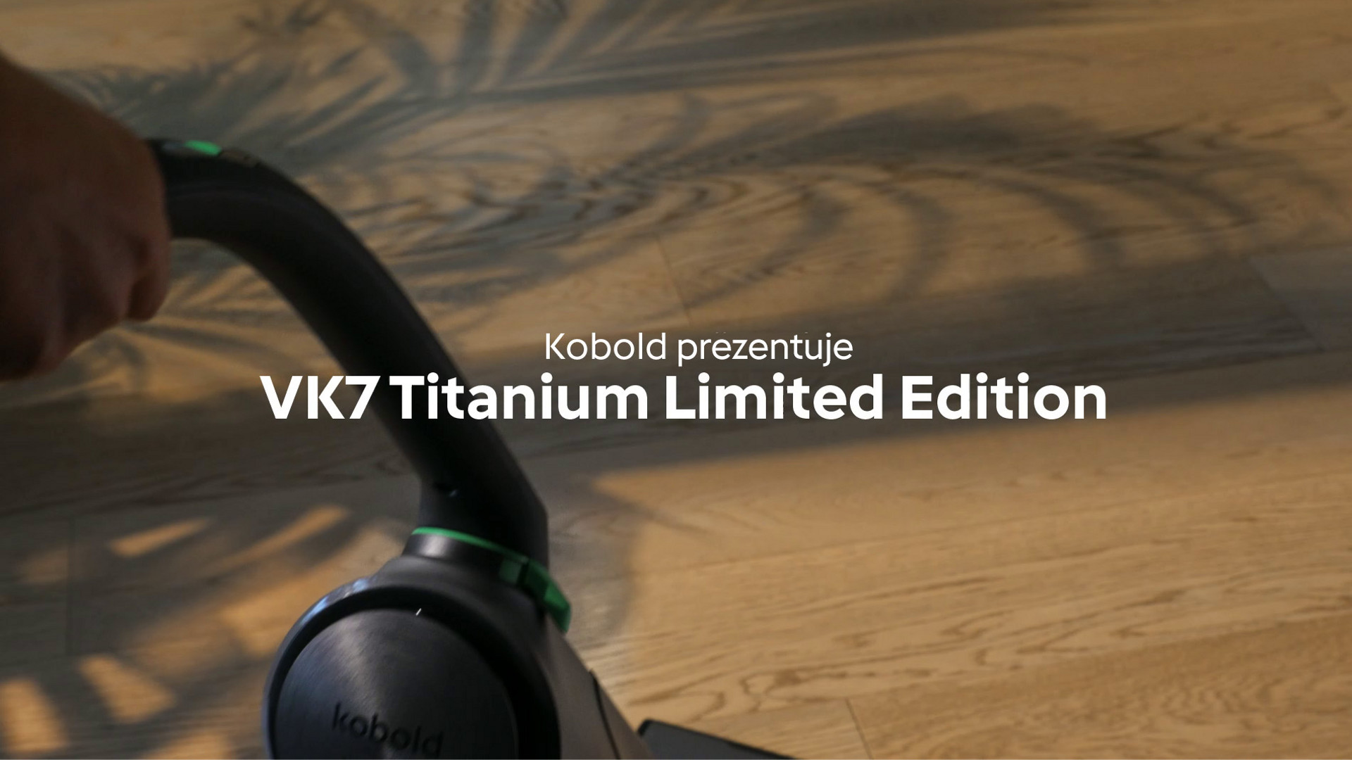 Zbliżenie na pionowy odkurzacz bezprzewodowy Kobold VK7 Titanium Limited Edition na drewnianej podłodze, nazwa produktu w tekście.
