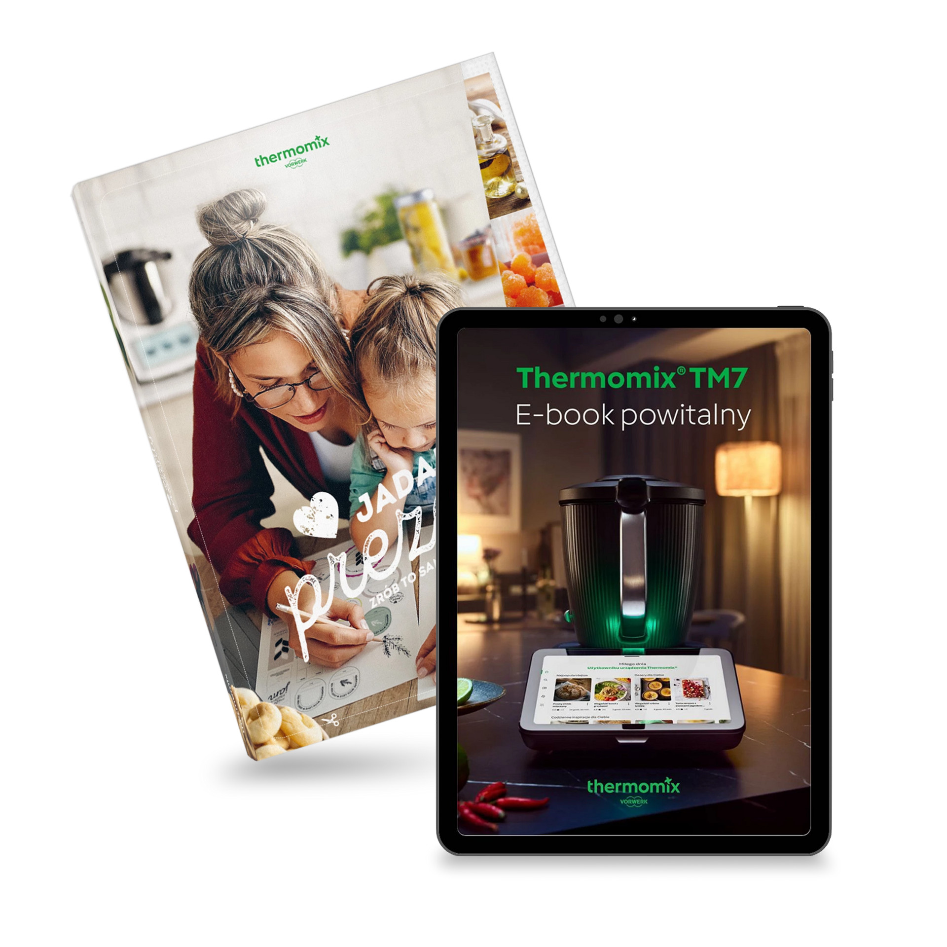 Powitalny e-book Thermomix® TM7 na tablecie obok książki kucharskiej z dwiema osobami przy stole kuchennym.