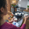 Mulher prepara sobremesas com Bimby TM6 colocando taças no Varoma numa cozinha doméstica