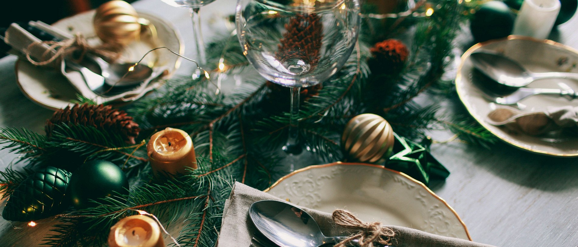 Table served for winter dinner in living room. Close up view, table setting. Christmas and winter decorations.