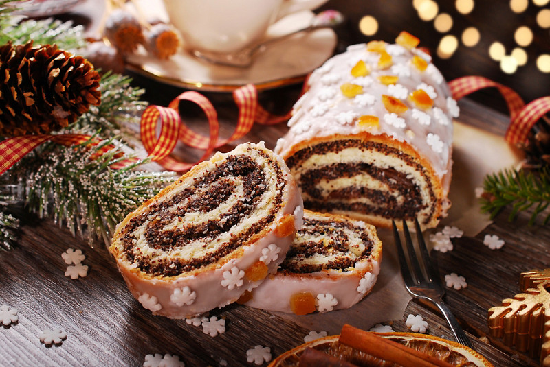 christmas poppy seed cake partly sleeced on wooden table in rustic style