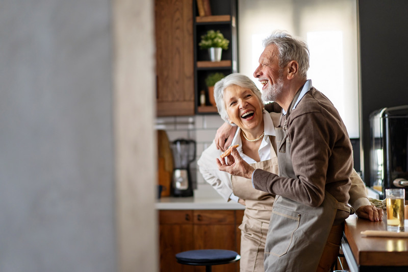 Happy mature couple communicating while having fun in the kitchen together