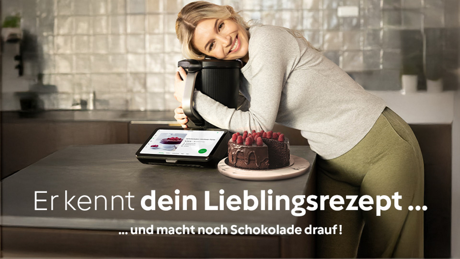 Frau umarmt den TM7. Daneben steht eine Schokotorte.
