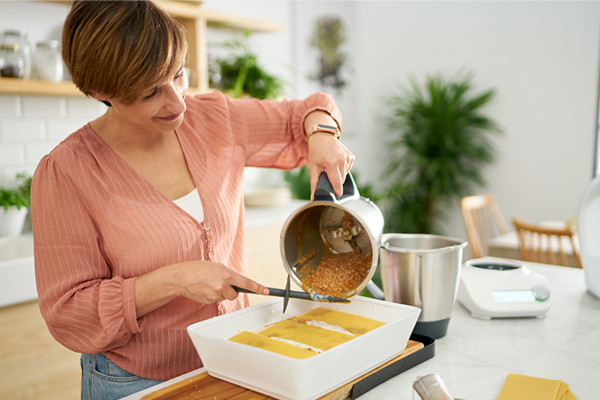 Mulher a cozinhar na Bimby® TM6 e na Bimby® Friend