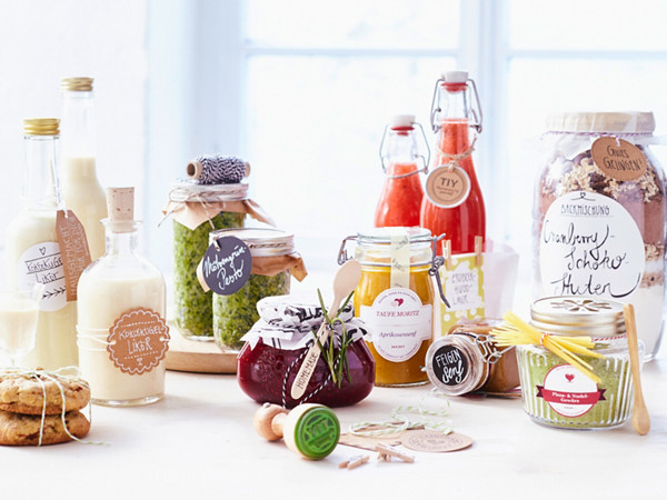 Das Bild zeigt mehrere Einmachgläser und Glasflaschen mit verschiedenen Etiketten