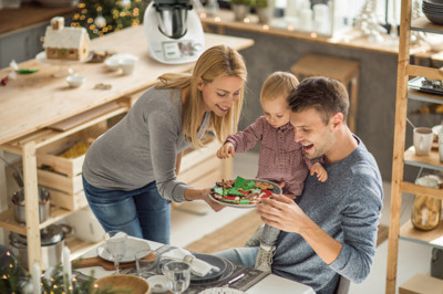 Family with one child preparing for Christmas feast, they all participate in preparation