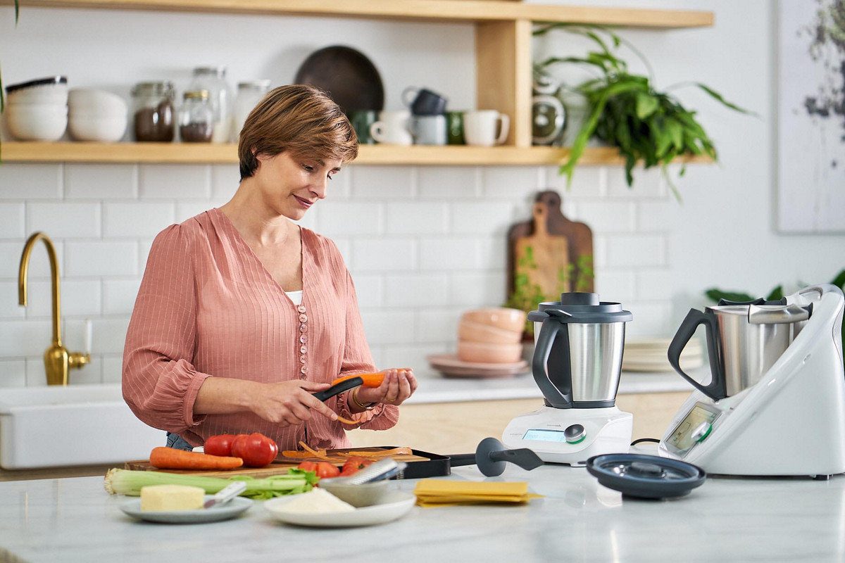 thermomix woman peels carrot tm friend ktichen pink shirt