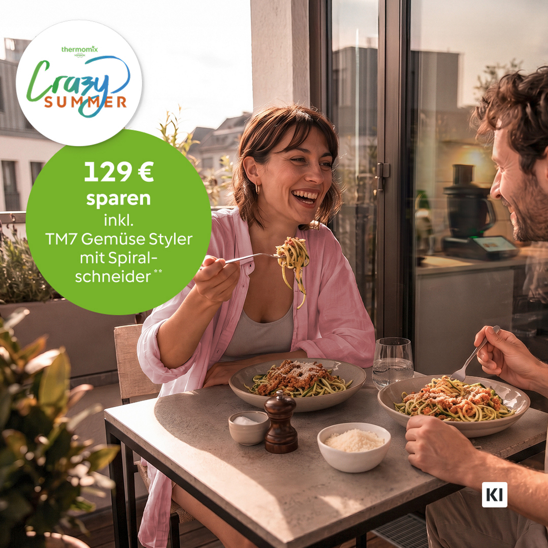 2 Personen essen Gemüse-Spaghetti auf dem Balkon. Im Hintergrund: TM7 mit Gemüse Styler. KI-generiert. Badge "129 € sparen".