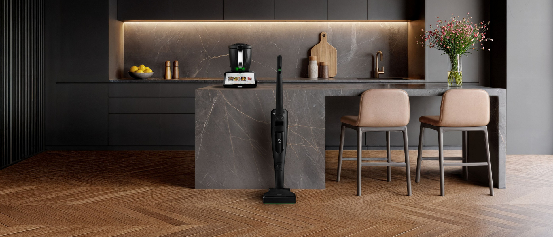 Nowoczesna kuchnia z Thermomix® TM7 na blacie i pionowym odkurzaczem bezprzewodowym Kobold VK7 Black Edition na wyspie.