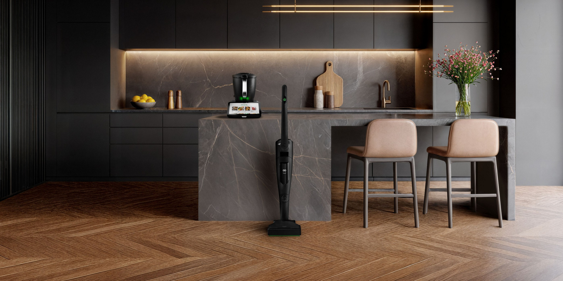 Nowoczesna kuchnia z Thermomix® TM7 na blacie i pionowym odkurzaczem bezprzewodowym Kobold VK7 Black Edition na wyspie.