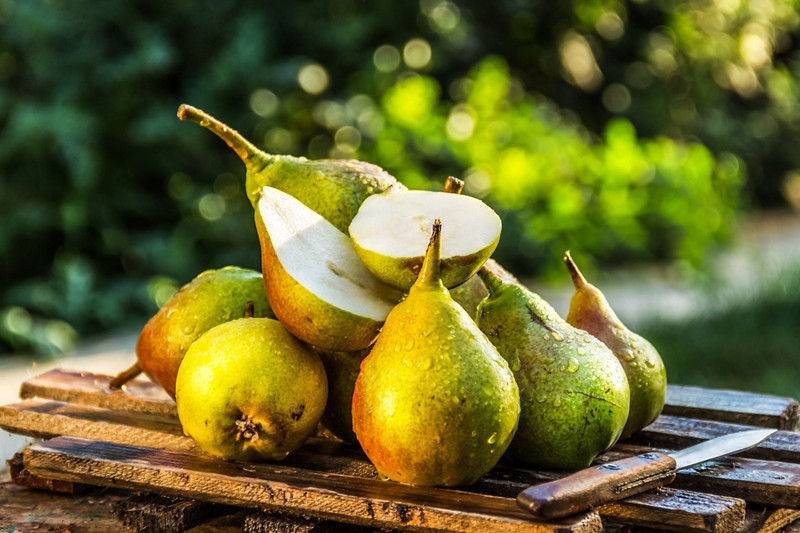 Juicy fresh pears on an old wooden board. Juicy ripe pears in a sunny garden. Harvesting. Garden fruits
